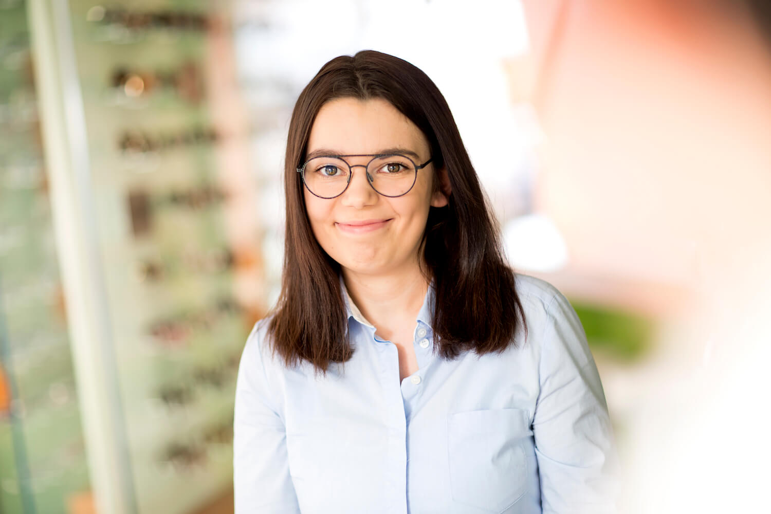 M. Wolter, Auszubildende bei Kunk neue optik in Bremen Frau lächelnd mit Brille im Brillengeschäft.